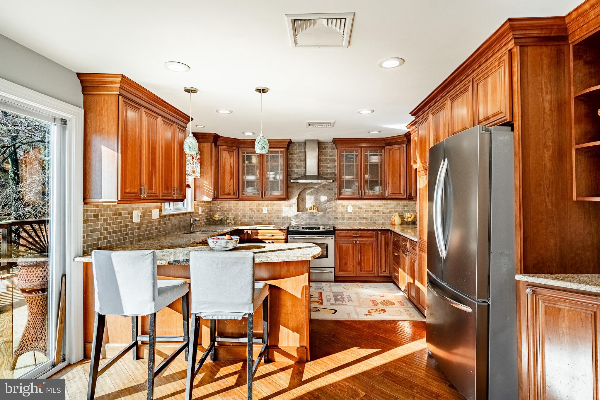 3920 Darby Road Bryn Mawr, PA 19010 - Photo 13 of 54 a kitchen with a refrigerator a stove a sink and a dining table with chairs