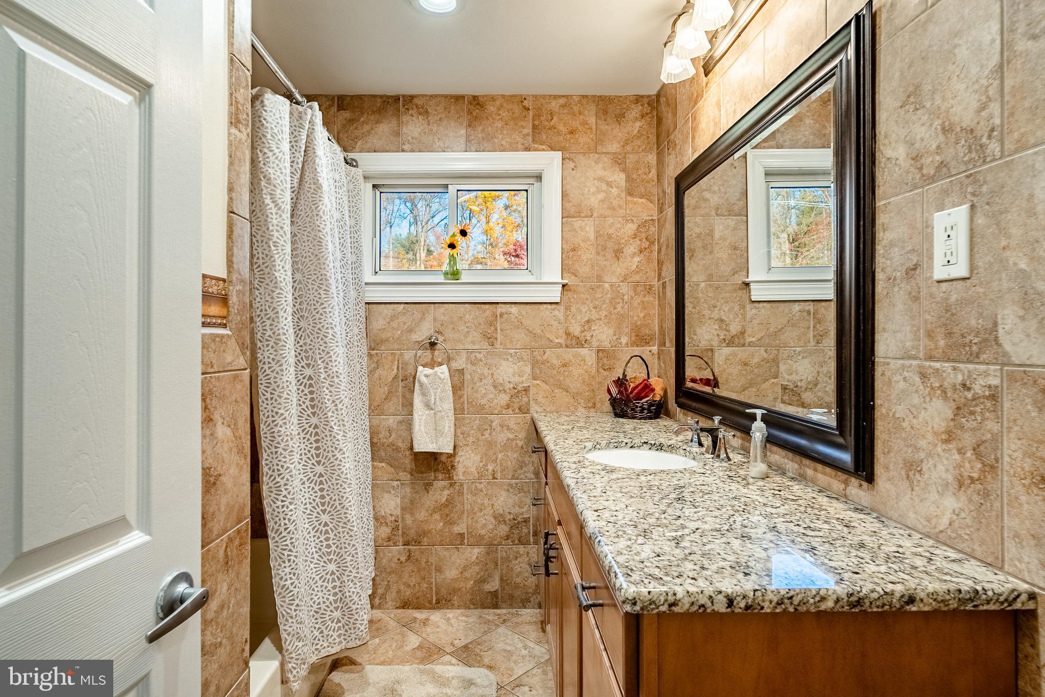 3920 Darby Road Bryn Mawr, PA 19010 - Photo 22 of 54 a bathroom with a granite countertop sink a mirror and a shower