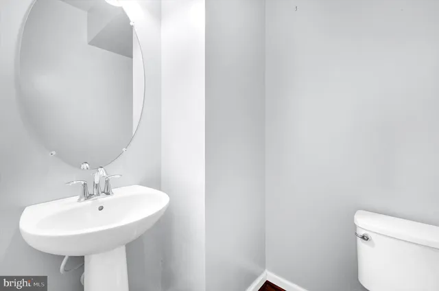 a bathroom with a sink a toilet and mirror