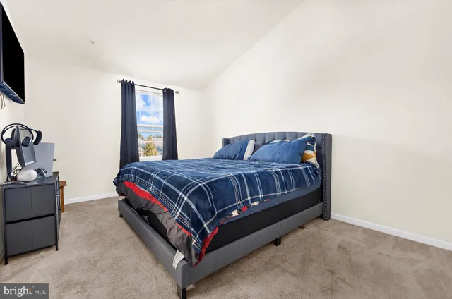 a bed sitting in a room next to a window with pc on the wall