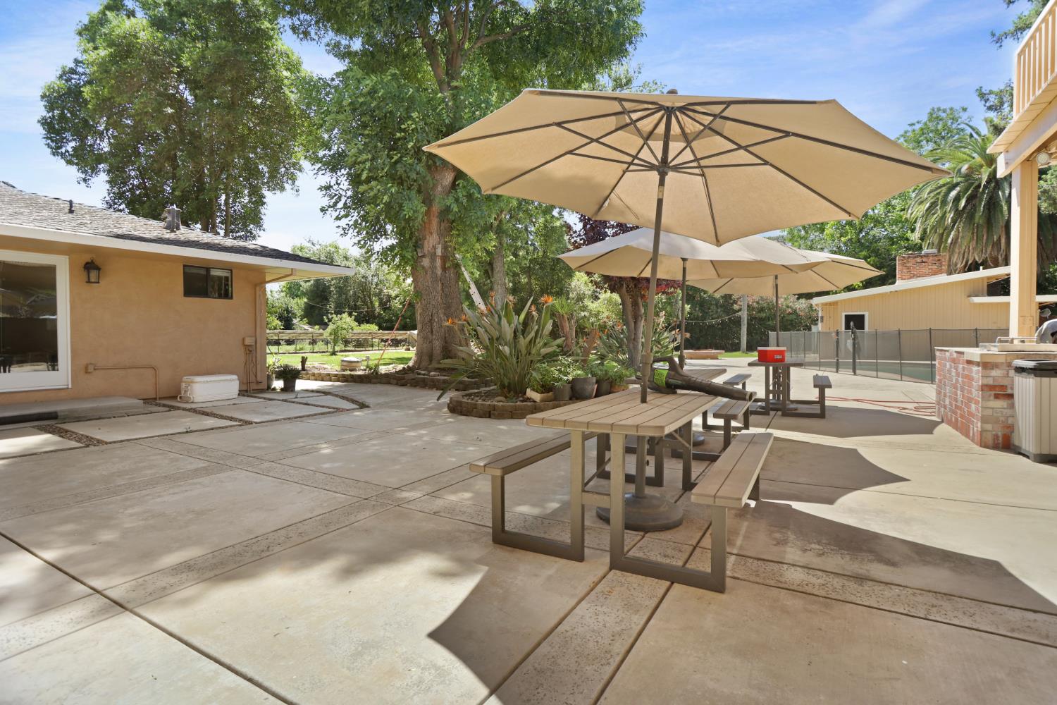 9935 Hazel Road Stockton, CA 95212 - Photo 81 of 98 a view of the patio with a table and chairs under an umbrella