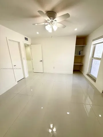 an empty room with a ceiling fan and a window