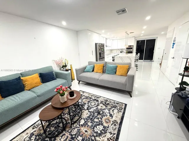 a living room with furniture and kitchen view