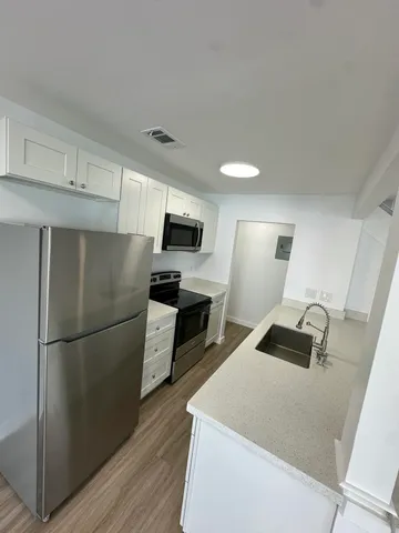 a kitchen with stainless steel appliances granite countertop a refrigerator a stove a sink and a refrigerator