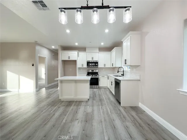 a kitchen with a white wooden cabinets and white stainless steel appliances