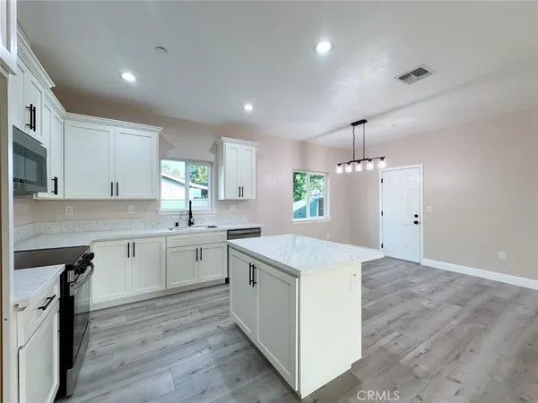 a kitchen with a white cabinets stove and refrigerator
