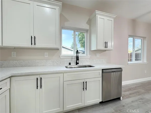 a kitchen with white cabinets and a sink