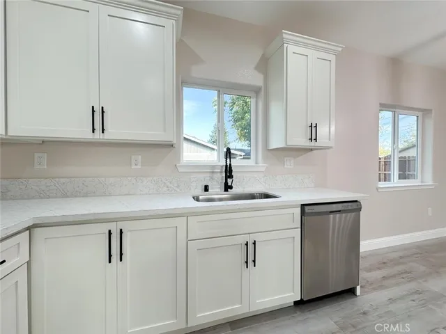 a kitchen with white cabinets and a sink