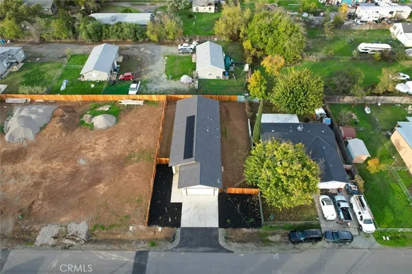 an aerial view of a house with a yard potted plants and large tree