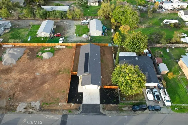 an aerial view of a house with a yard potted plants and large tree