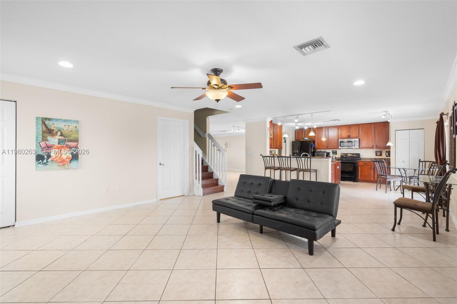 4628 Southwest 129th Avenue Miramar, FL 33027 - Photo 12 of 36 a living room with furniture a rug and white walls