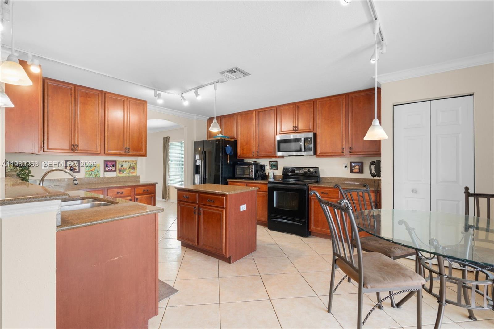 4628 Southwest 129th Avenue Miramar, FL 33027 - Photo 14 of 36 a kitchen with stainless steel appliances granite countertop a refrigerator a stove top oven a sink dishwasher and wooden cabinets