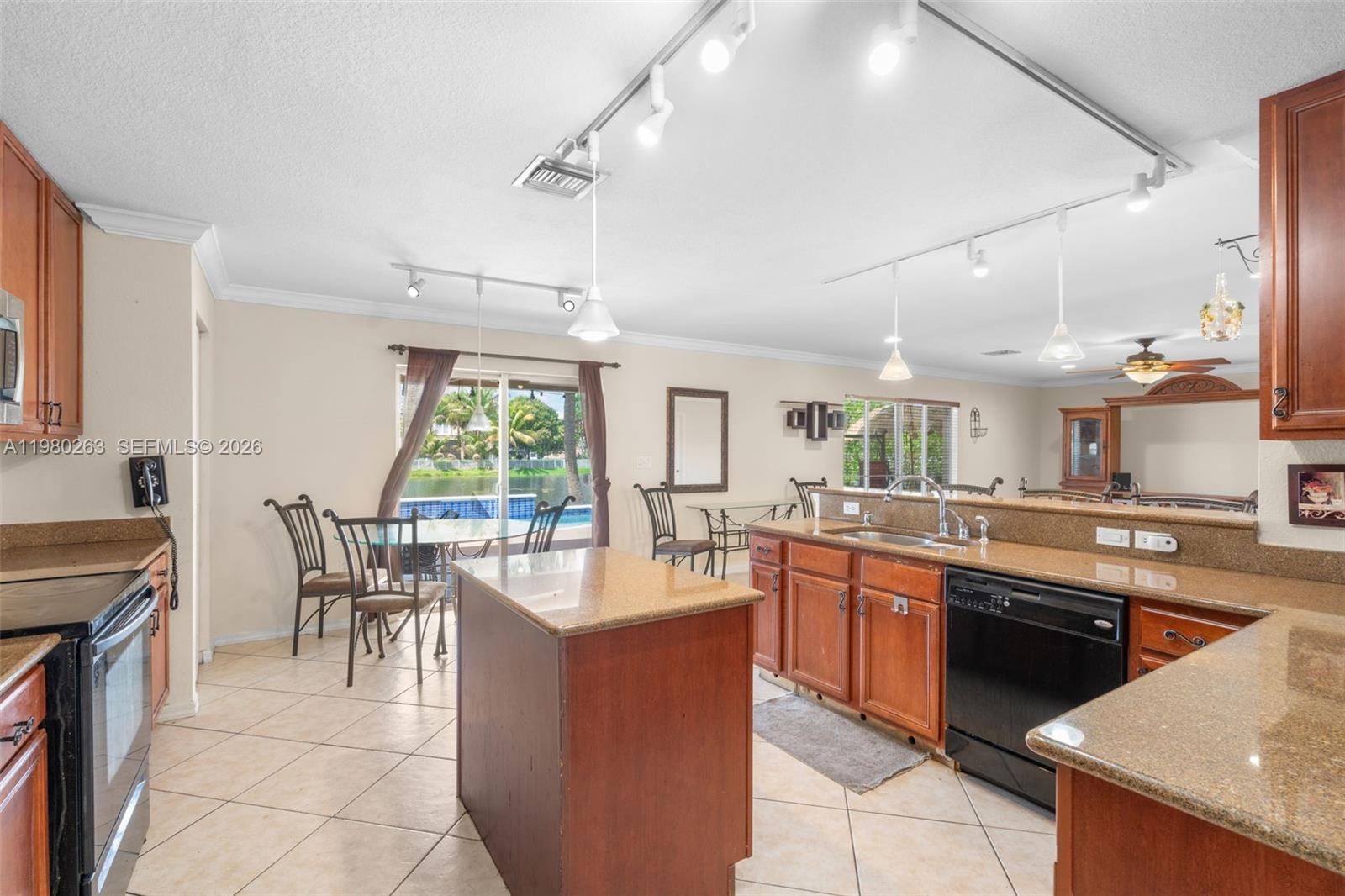 4628 Southwest 129th Avenue Miramar, FL 33027 - Photo 15 of 36 a dining hall with stainless steel appliances granite countertop a stove top oven a sink dishwasher a dining table and chairs with wooden floor