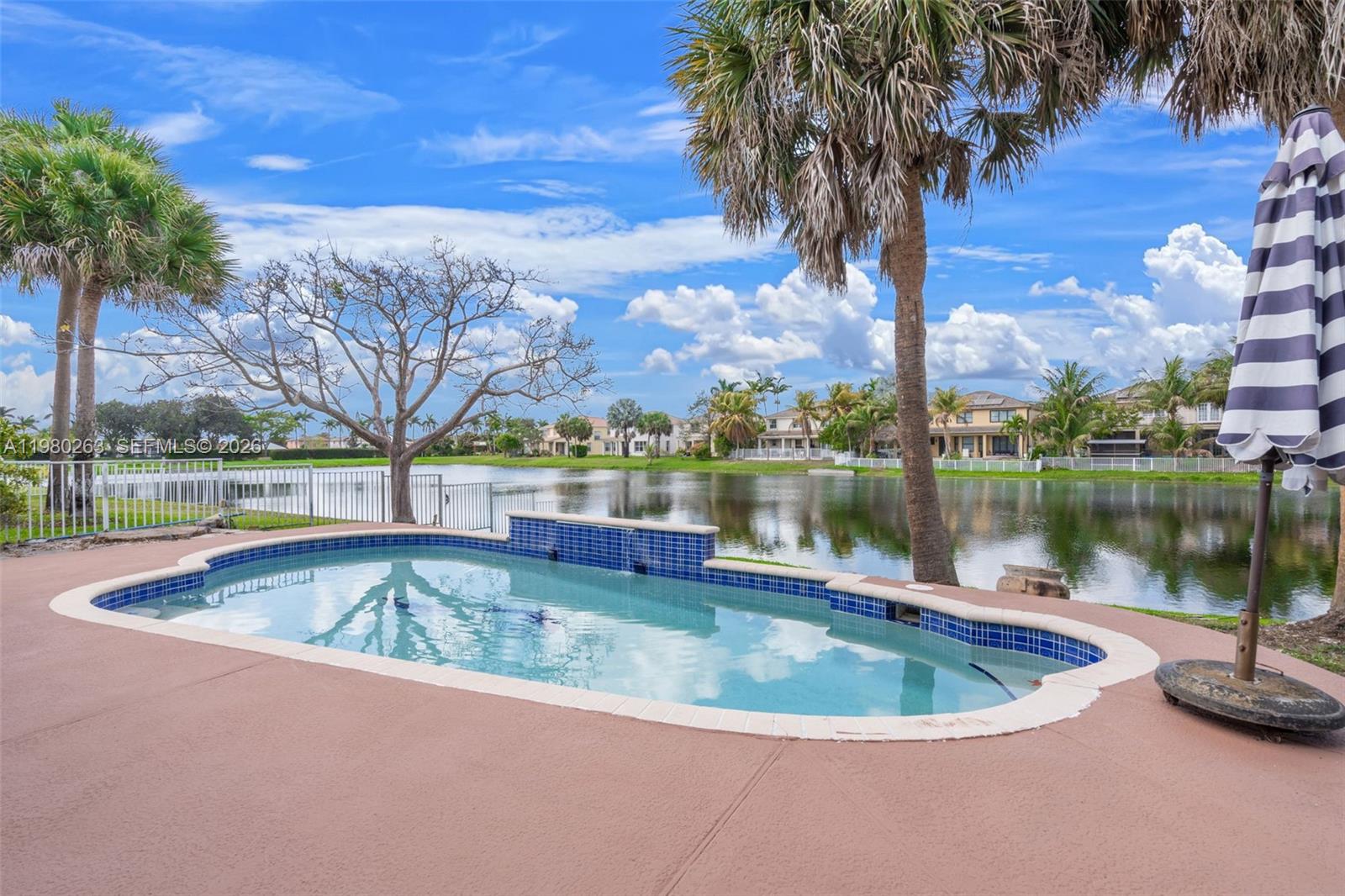 4628 Southwest 129th Avenue Miramar, FL 33027 - Photo 2 of 36 a view of a swimming pool and trees in the background