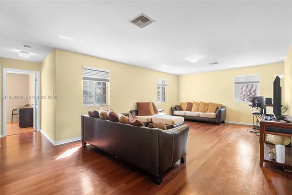 a living room with furniture and a wooden floor