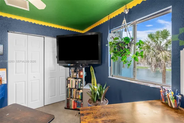 a living room with flat screen tv and a potted plant