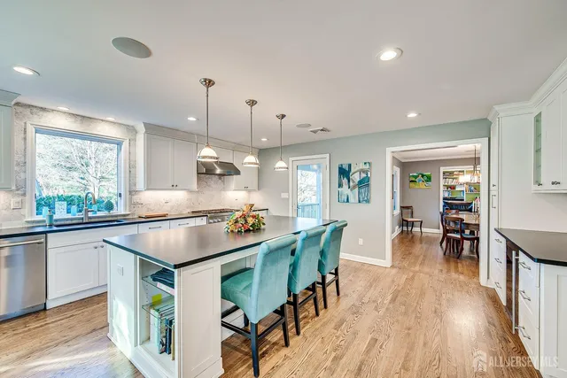 a kitchen with granite countertop a sink a stove and wooden floor