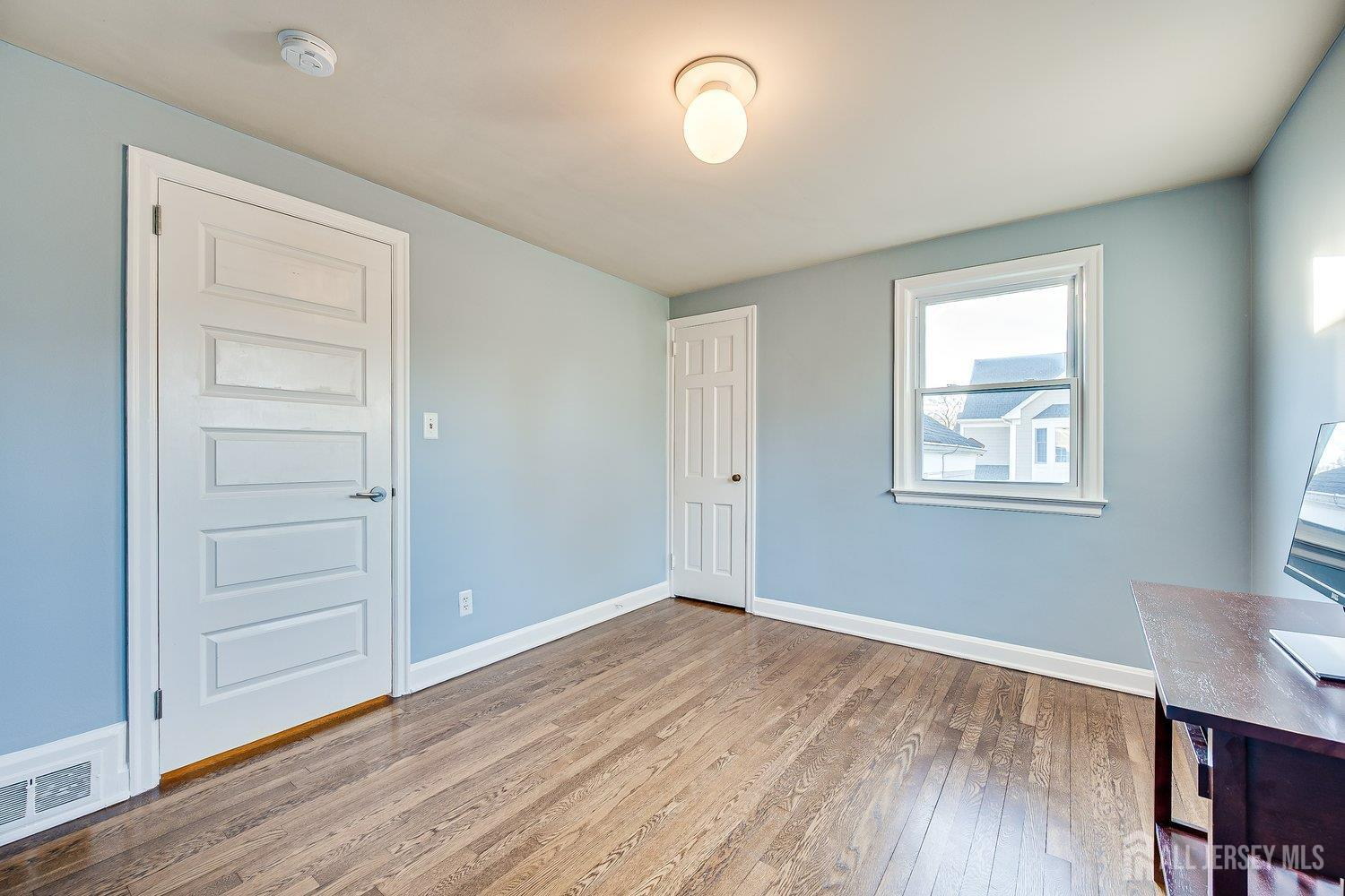 62 Spring Street Metuchen, NJ 08840 - Photo 30 of 47 an empty room with wooden floor closet and windows