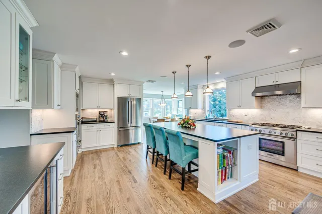 a kitchen with stainless steel appliances granite countertop a table and chairs in it