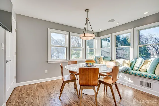 a dining room with furniture a chandelier and wooden floor
