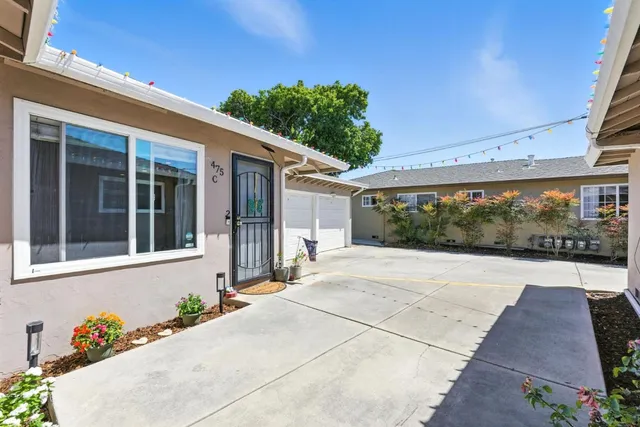 a front view of a house with a yard and potted plants