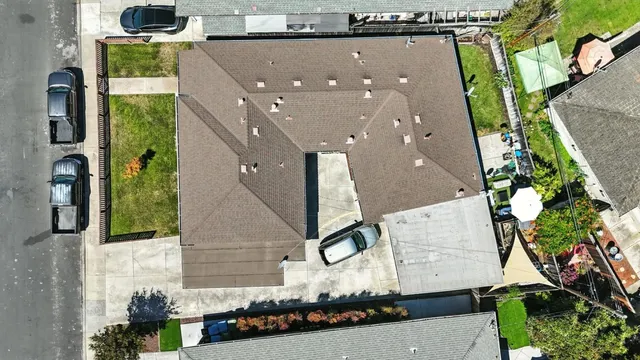 an aerial view of a house with large trees and entryway