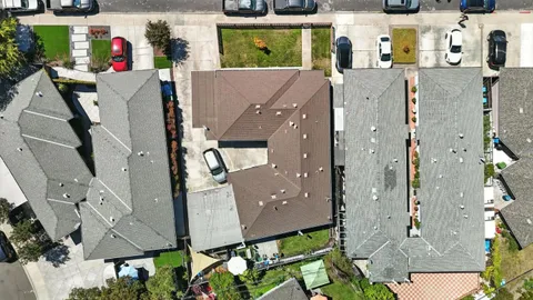 an aerial view of residential houses with outdoor space and parking