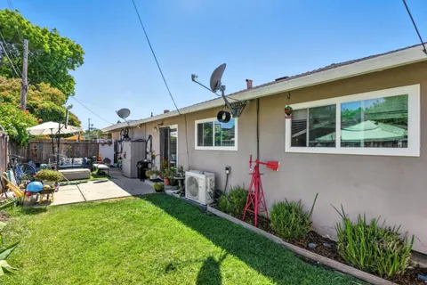 a view of a house with backyard sitting area and garden