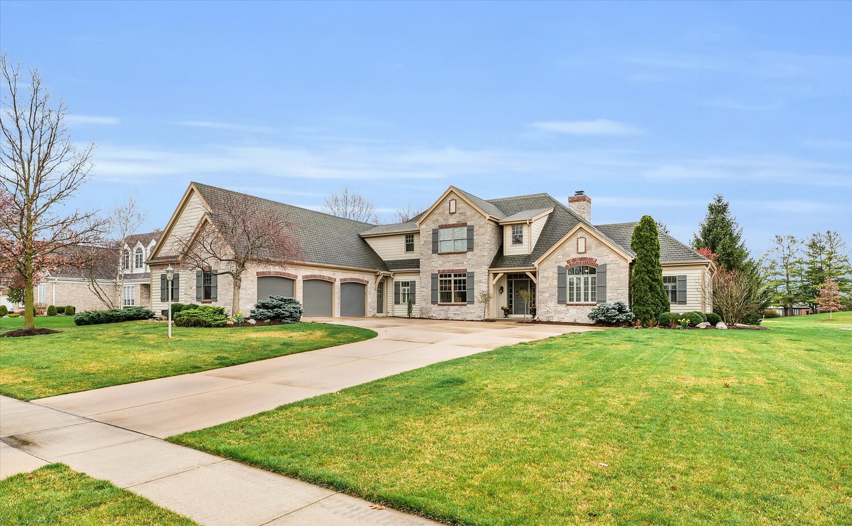 a view of a big house with a big yard and large trees