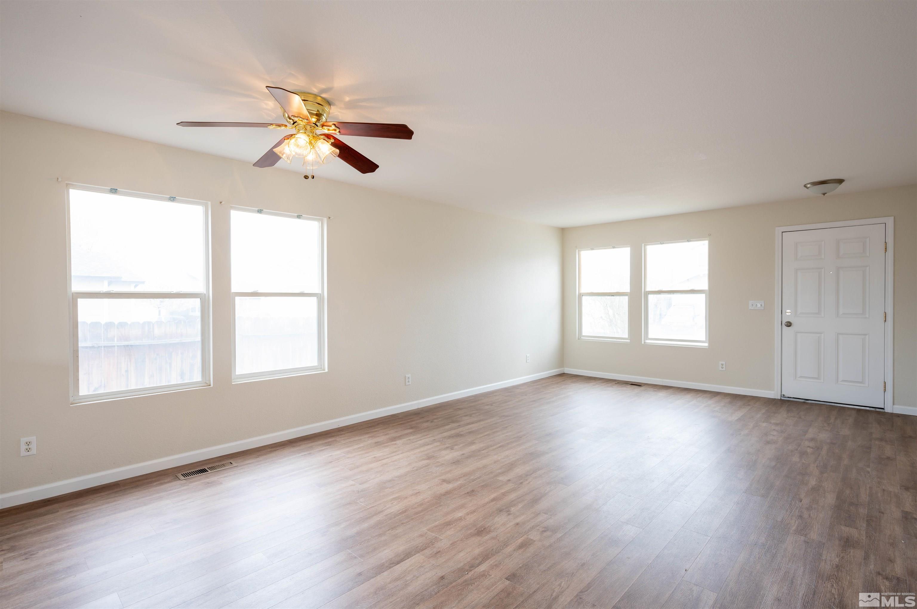 9615 Autumn Leaf Way Reno, NV 89506 - Photo 6 of 24 an empty room with wooden floor fan and windows