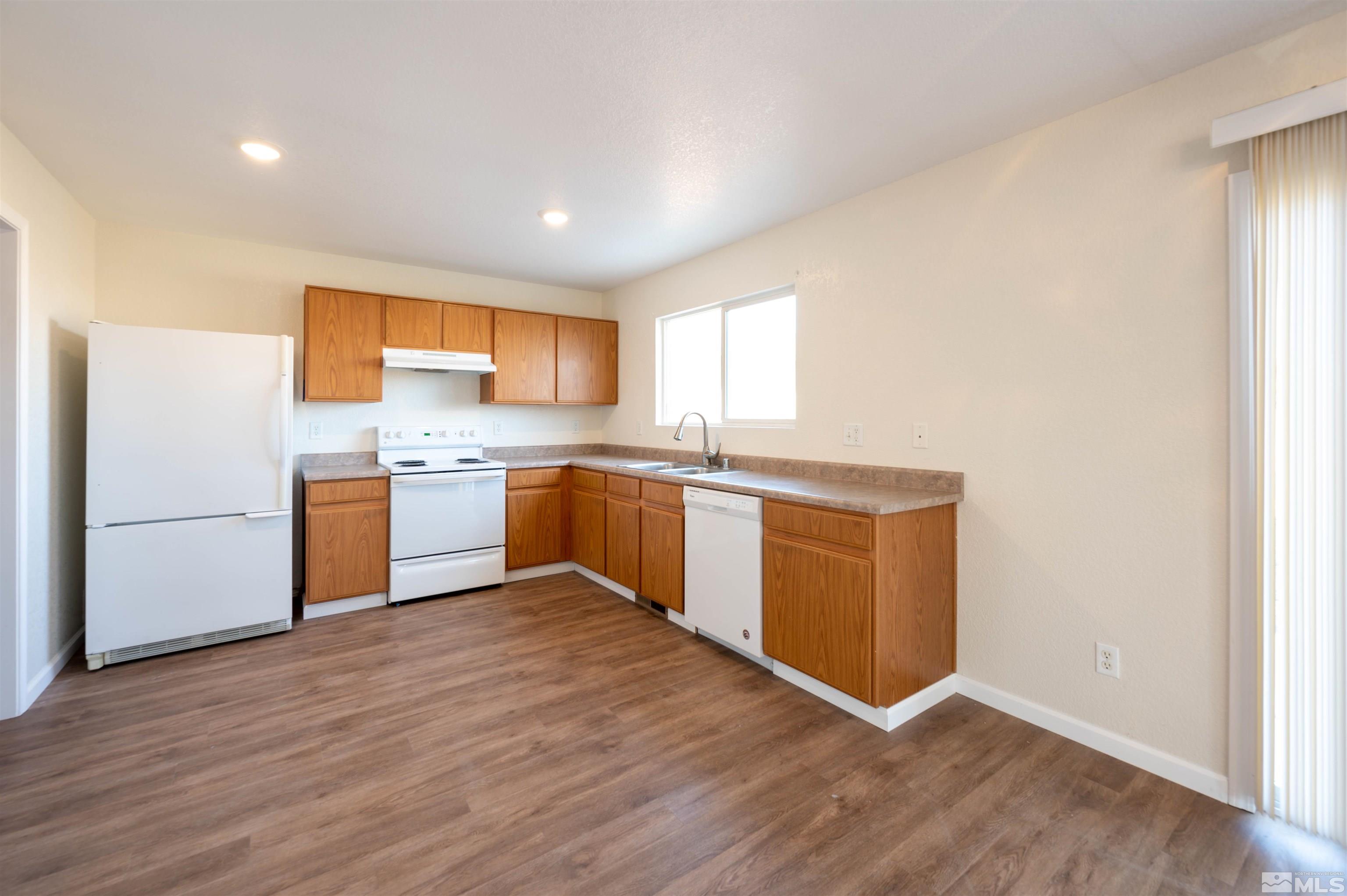 9615 Autumn Leaf Way Reno, NV 89506 - Photo 8 of 24 a kitchen with wooden floors and white stainless steel appliances