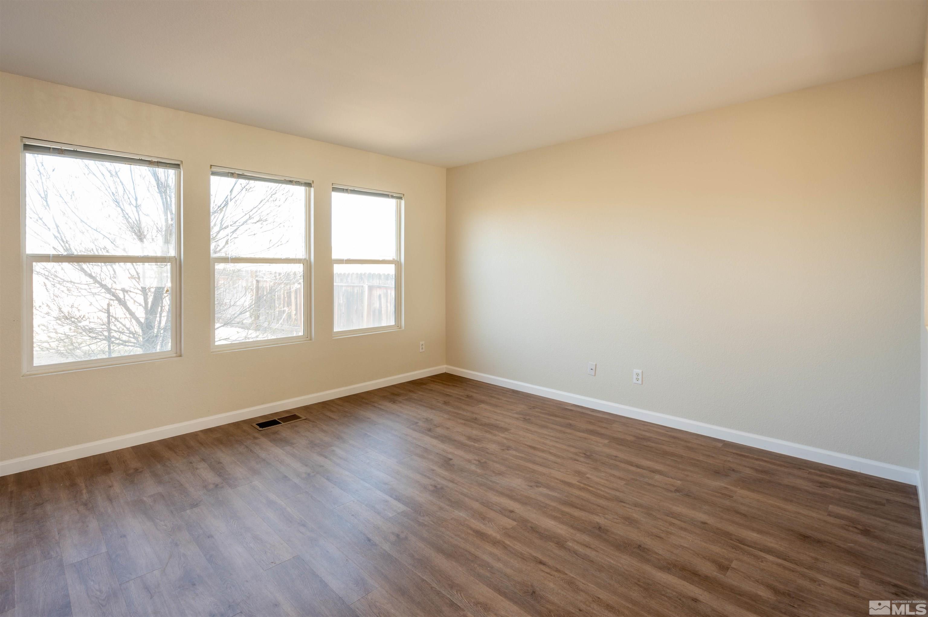 9615 Autumn Leaf Way Reno, NV 89506 - Photo 9 of 24 an empty room with wooden floor and windows