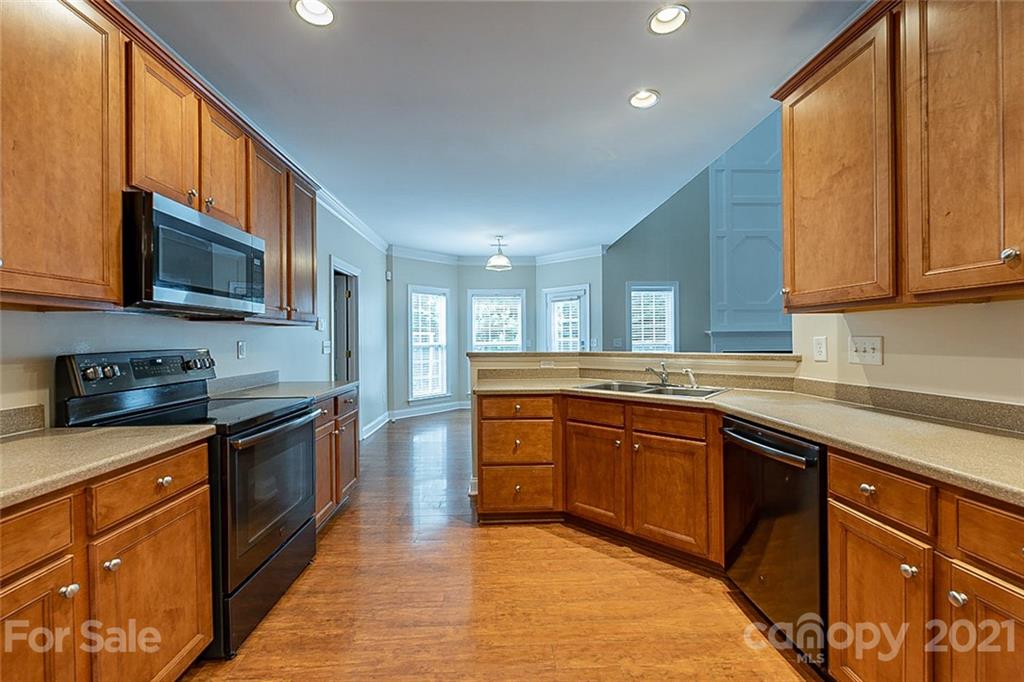 3546 Weddington Ridge Lane Matthews, NC 28105 - Photo 4 of 24 a large kitchen with stainless steel appliances granite countertop wooden cabinets a sink and a stove