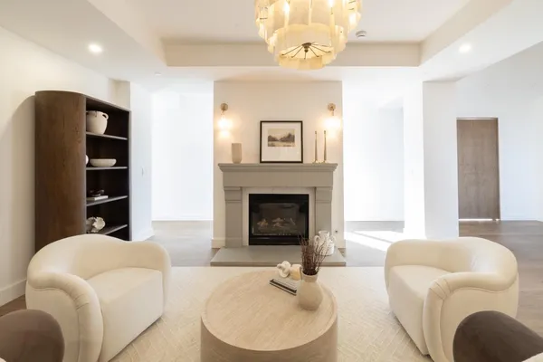 a living room with furniture a chandelier and a fireplace
