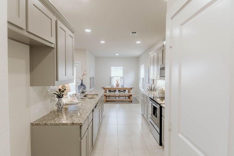 1104 Alexander Street Trenton, TX 75490 - Photo 10 of 18 Kitchen with stainless steel appliances, light tile patterned floors, light stone counters, backsplash, and recessed lighting