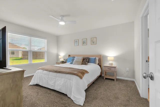 a spacious bedroom with a bed and glass windows