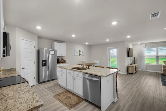 a kitchen with stainless steel appliances granite countertop a sink stove and refrigerator