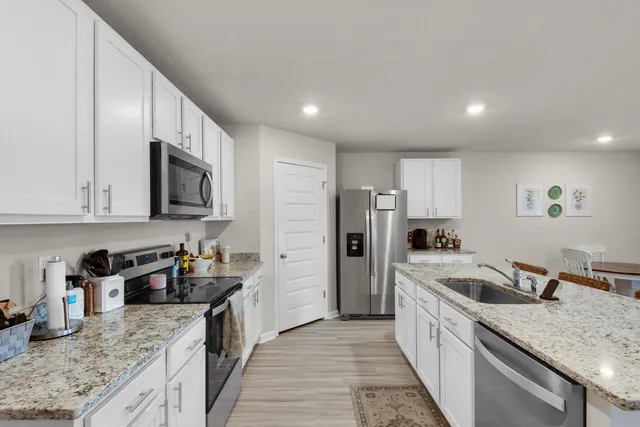 a kitchen with stainless steel appliances granite countertop a sink stove and refrigerator