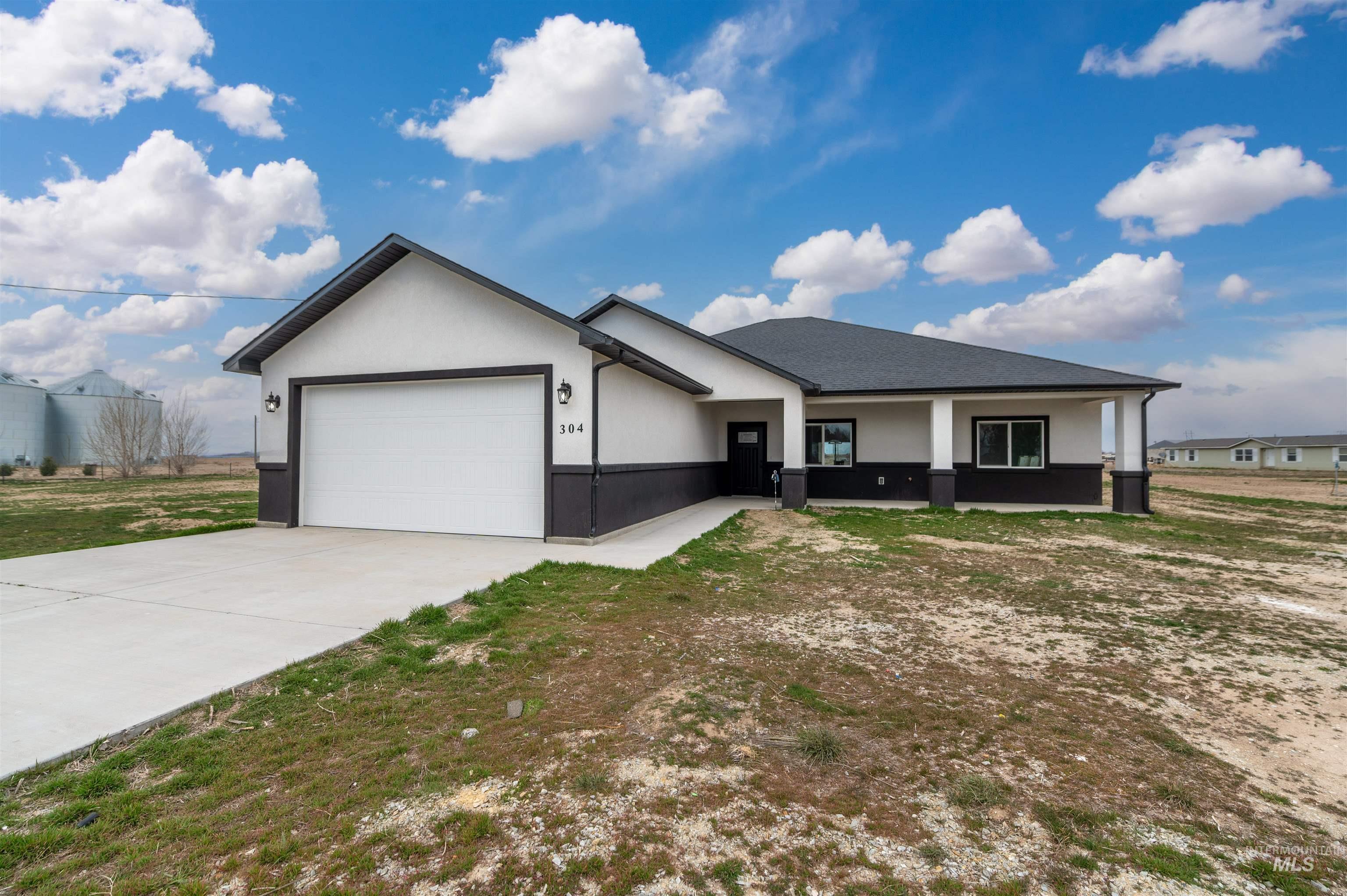304 Shillington Court Rupert, ID 83350 - Photo 4 of 40 Ranch-style house with an attached garage, concrete driveway, and stucco siding