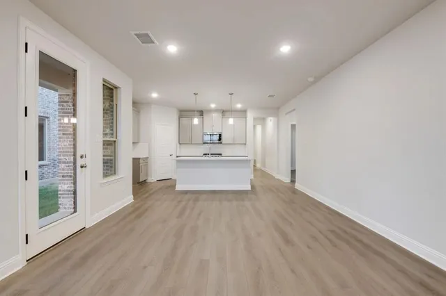 a view of a kitchen with wooden floor and windows