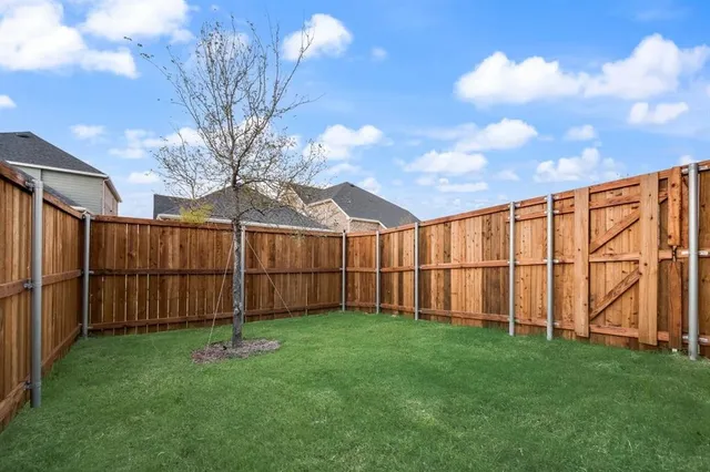 a view of a backyard with a fence and plants