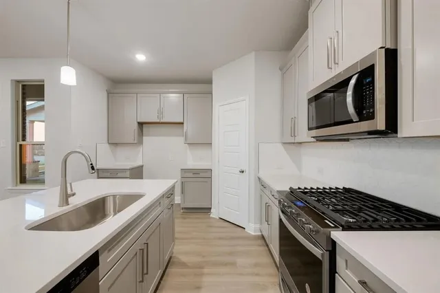 a kitchen with stainless steel appliances granite countertop a sink stove and microwave
