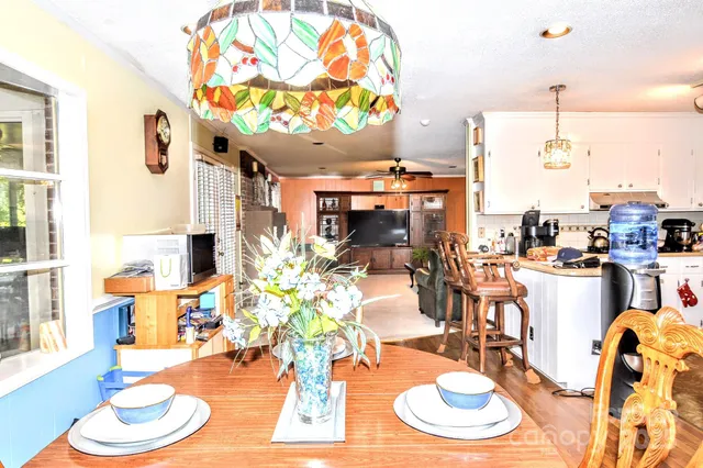 a dining room with furniture a kitchen view and wooden floor