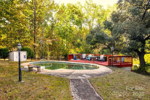a view of yard with swimming pool and trees