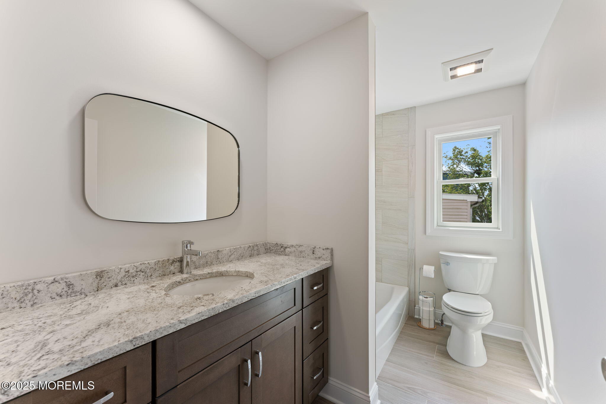 1413 George Street Point Pleasant, NJ 08742 - Photo 29 of 51 a bathroom with a granite countertop toilet a sink and a mirror