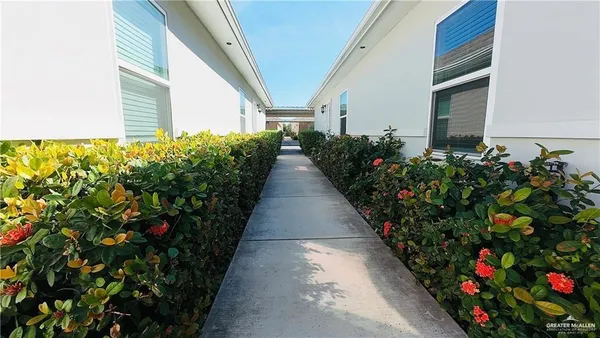 a potted plant sitting in front of a house with a flower garden