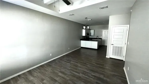 a kitchen with granite countertop white cabinets and wooden floor