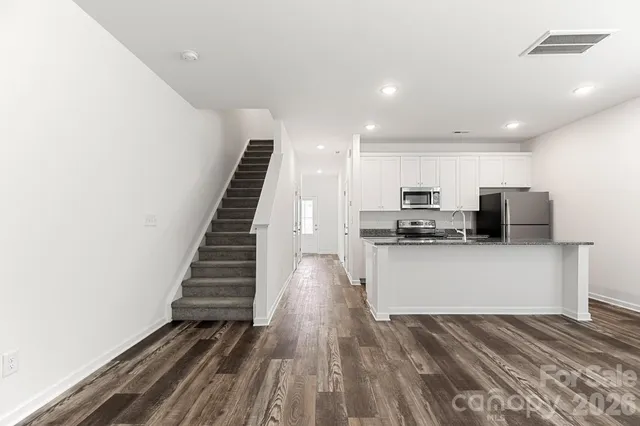 a view of kitchen with sink and refrigerator