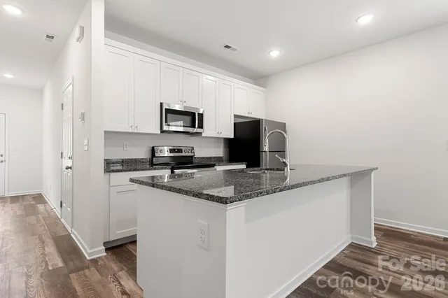 a kitchen with a sink a microwave a refrigerator and cabinets