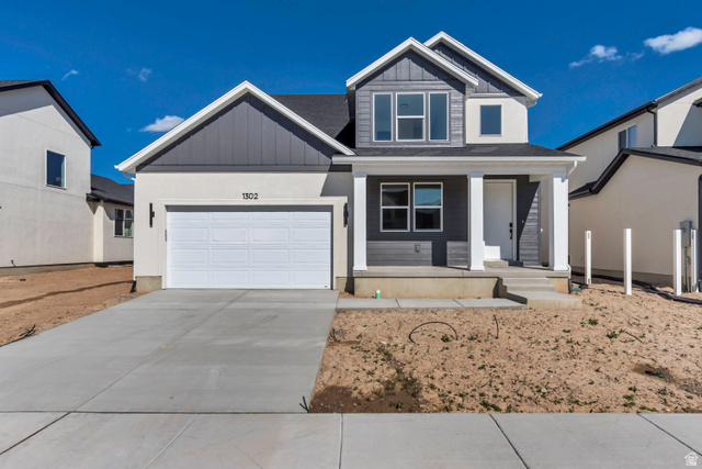 1302 1475 East, Unit 40 Payson, UT 84651 - Photo 1 of 34 View of front of property featuring board and batten siding, covered porch, a garage, and driveway